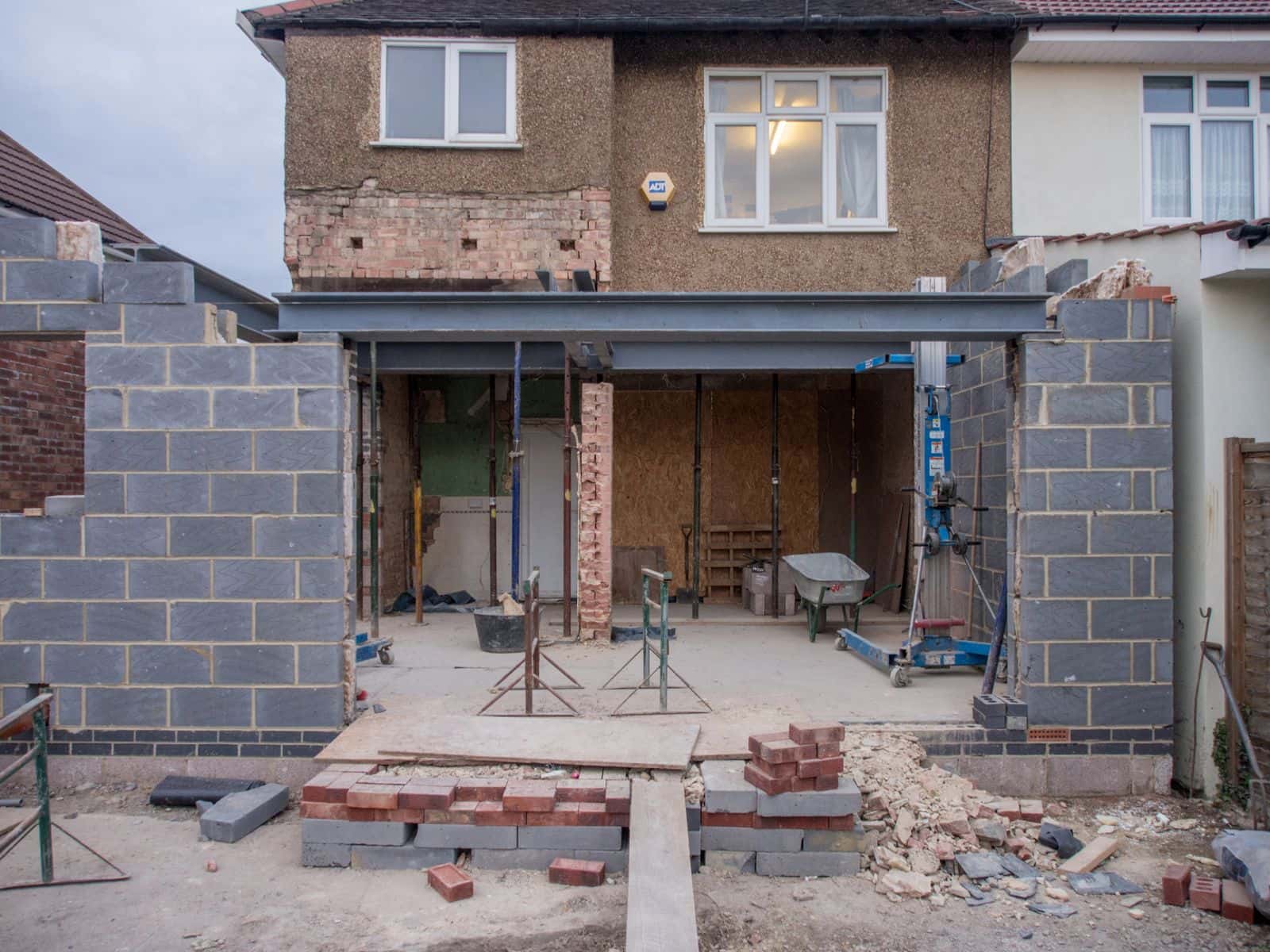 A house extension under construction, with new blockwork and a steel beam over the opening