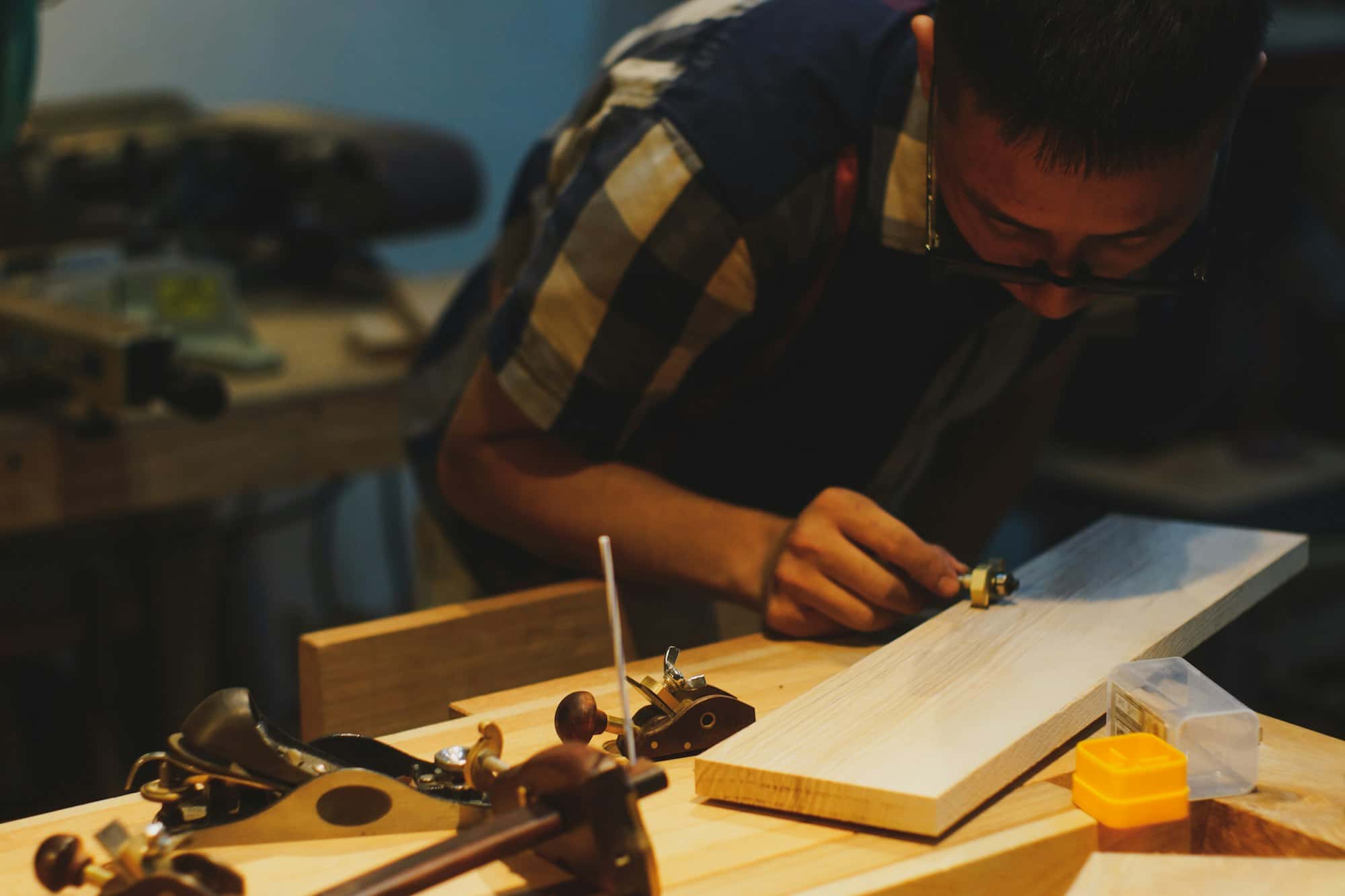 A joiner working on a length of timber at a workbench