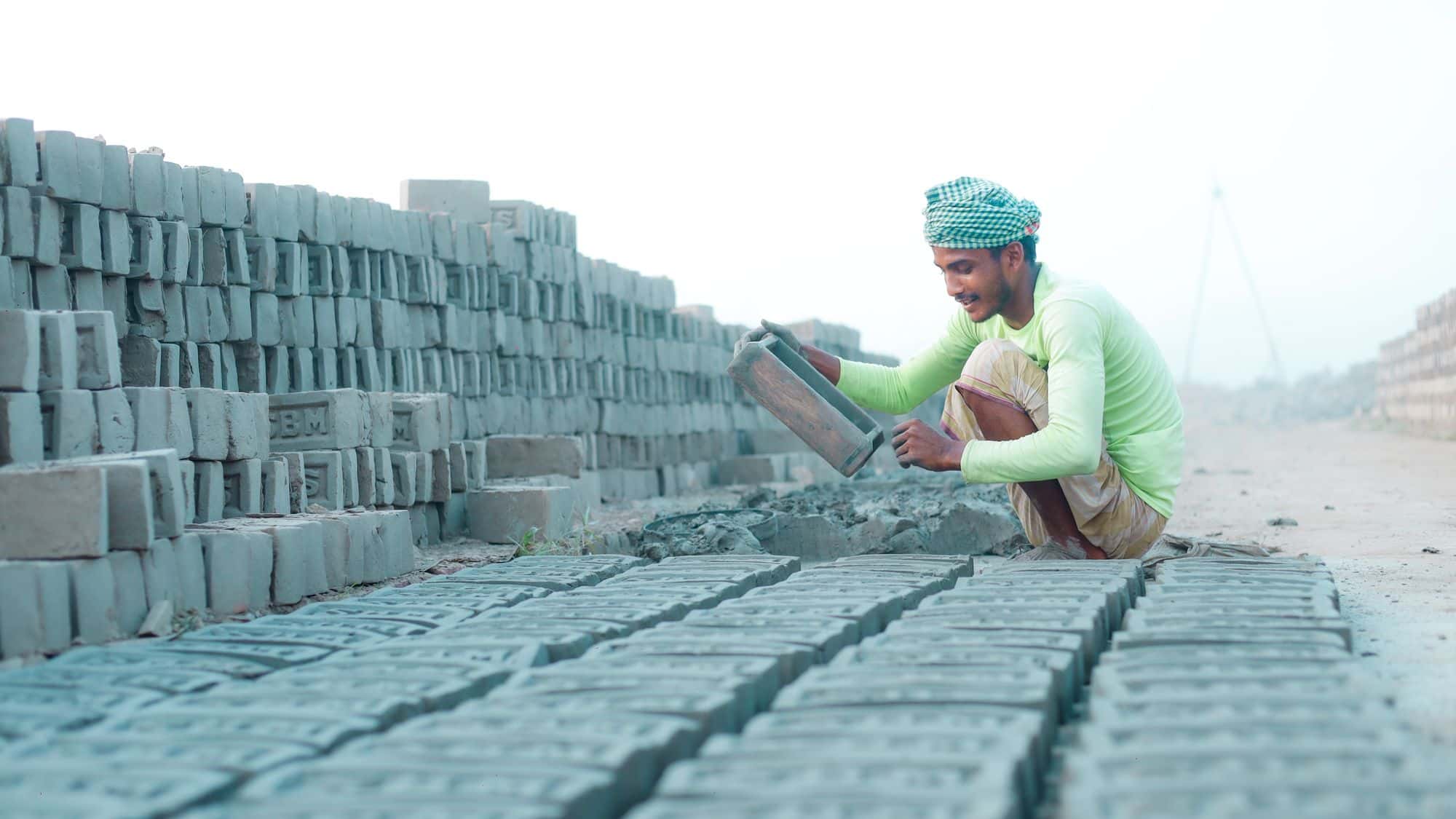 A bricklayer laying concrete blocks on a site