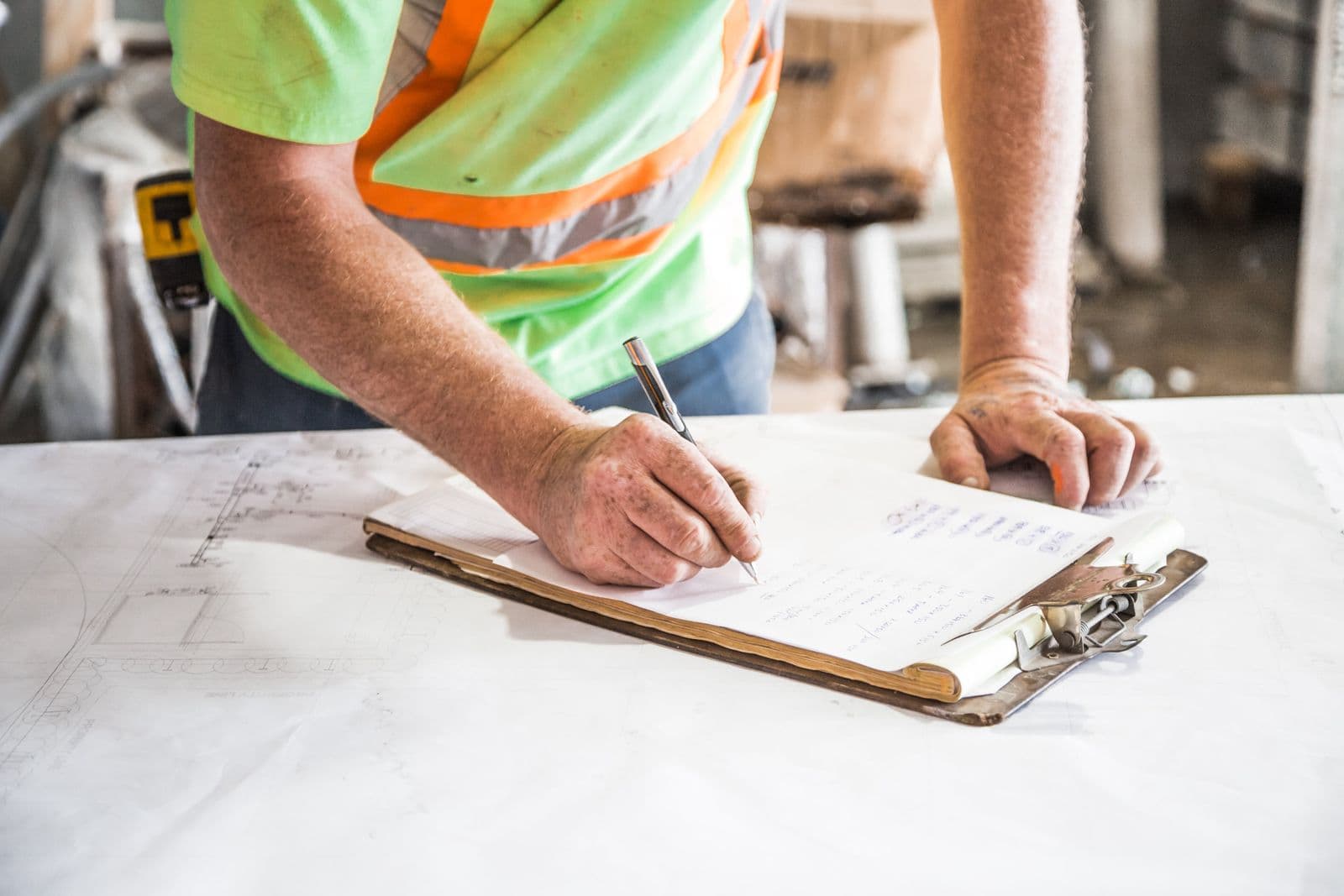 A contractor filling in paperwork on site drawings