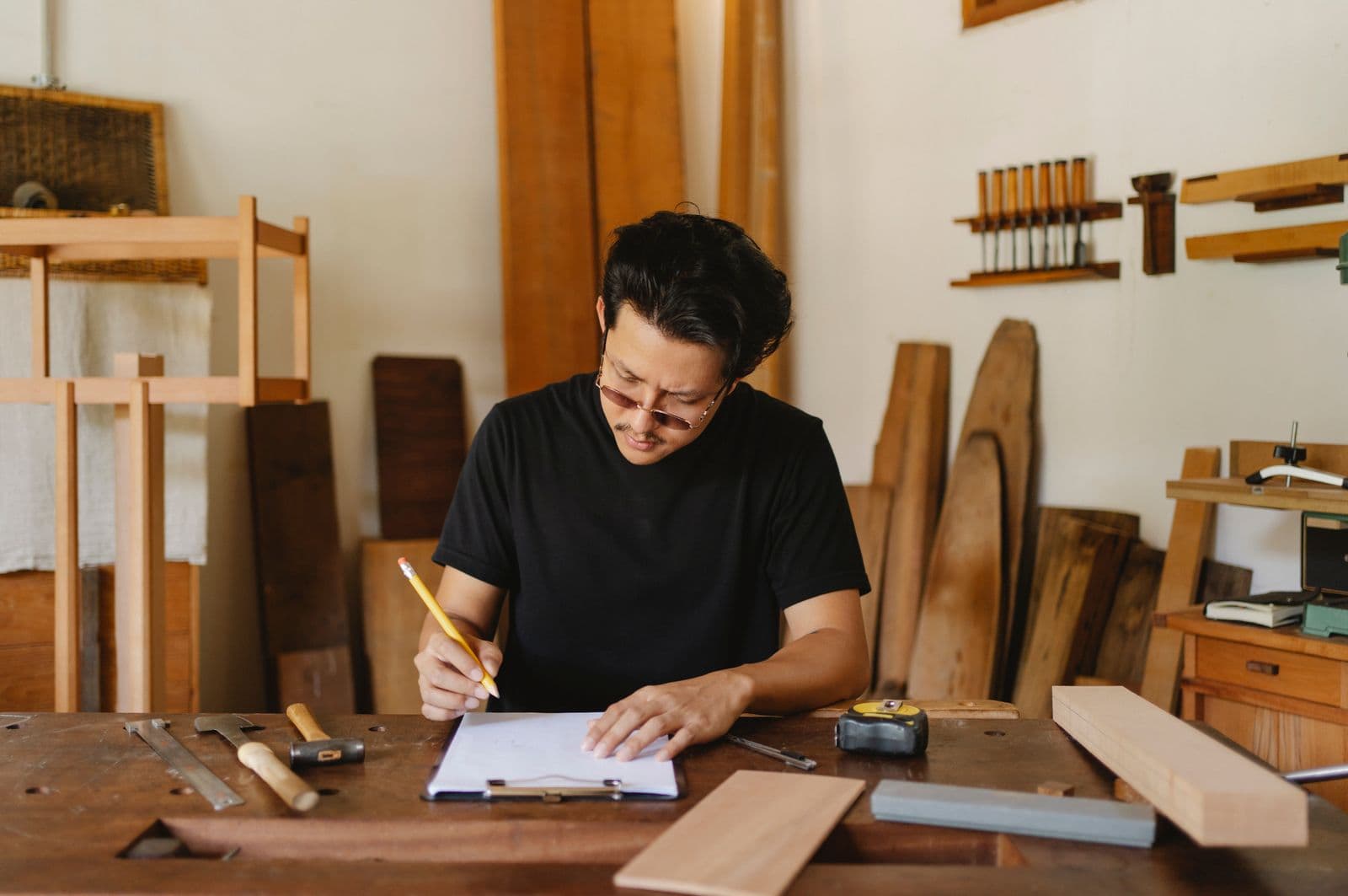 A joiner writing up paperwork in his workshop