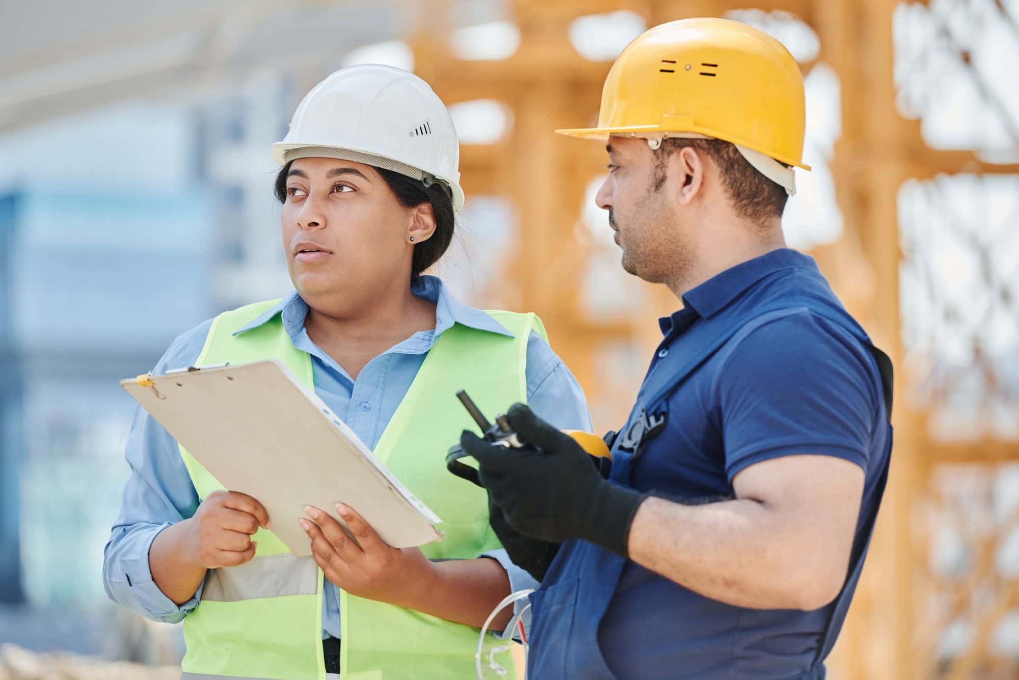 Two people on site checking something against a clipboard